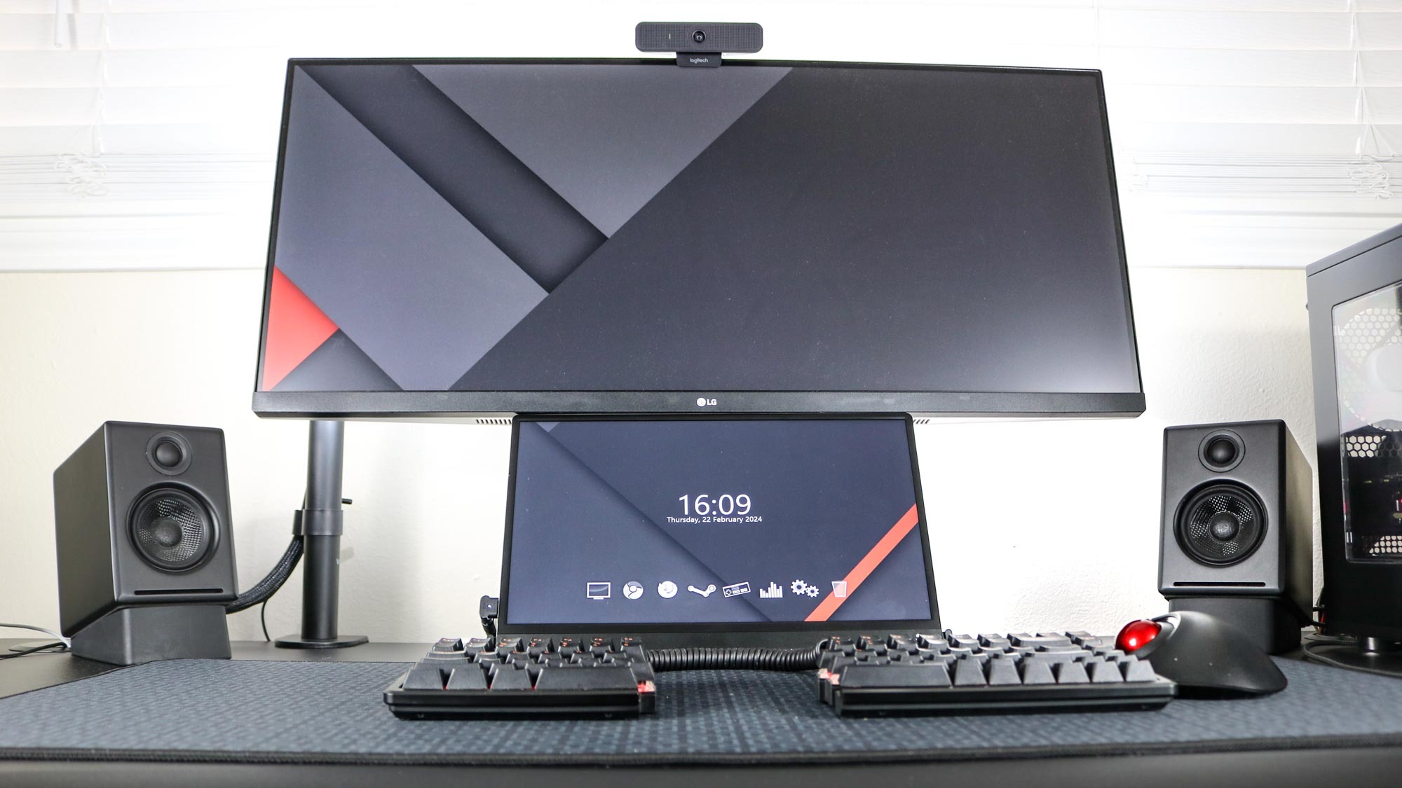 Un moniteur portable sous un moniteur ultra-large sur un bureau